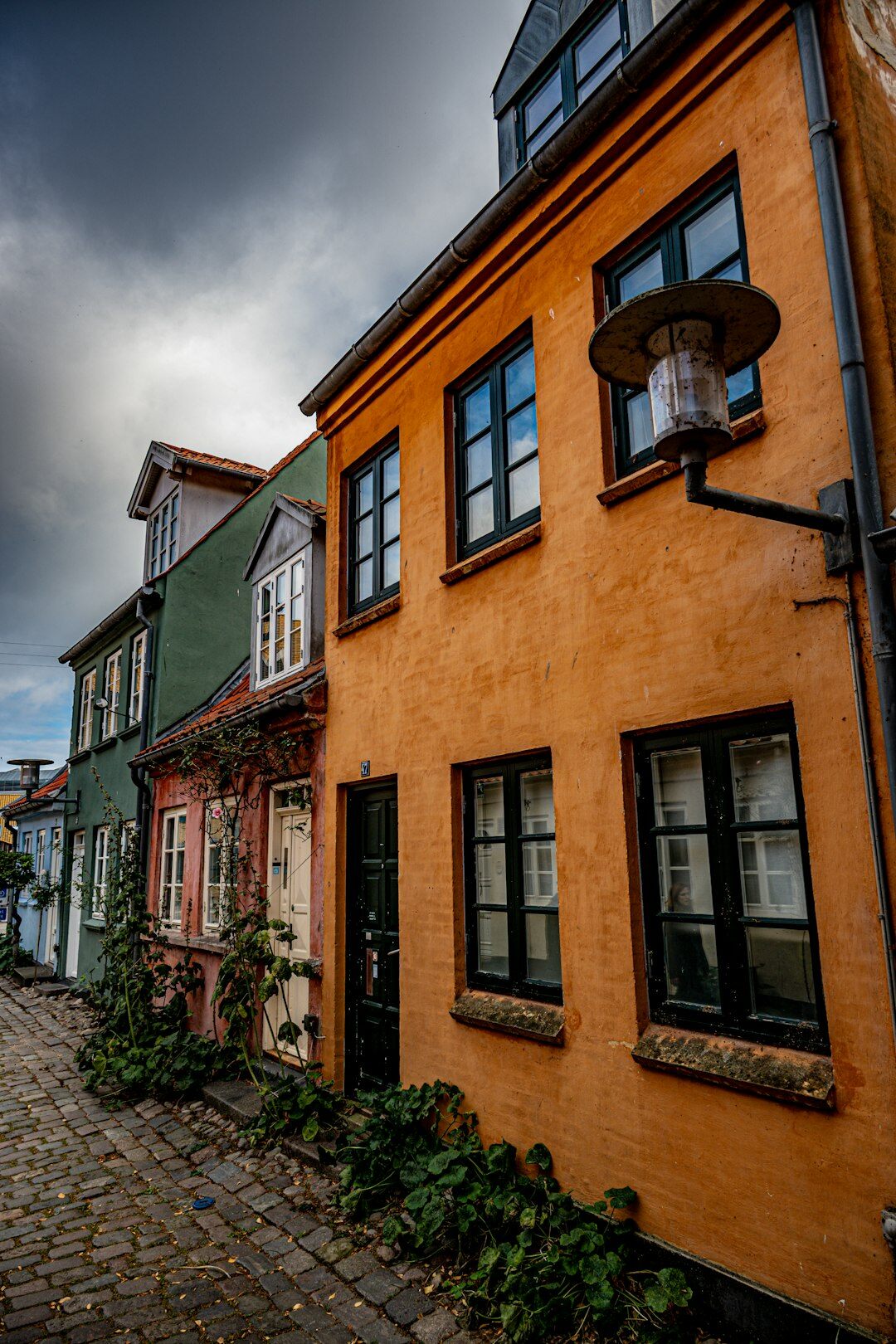 Narrow cobblestone street in a historic Danish town with colourful houses