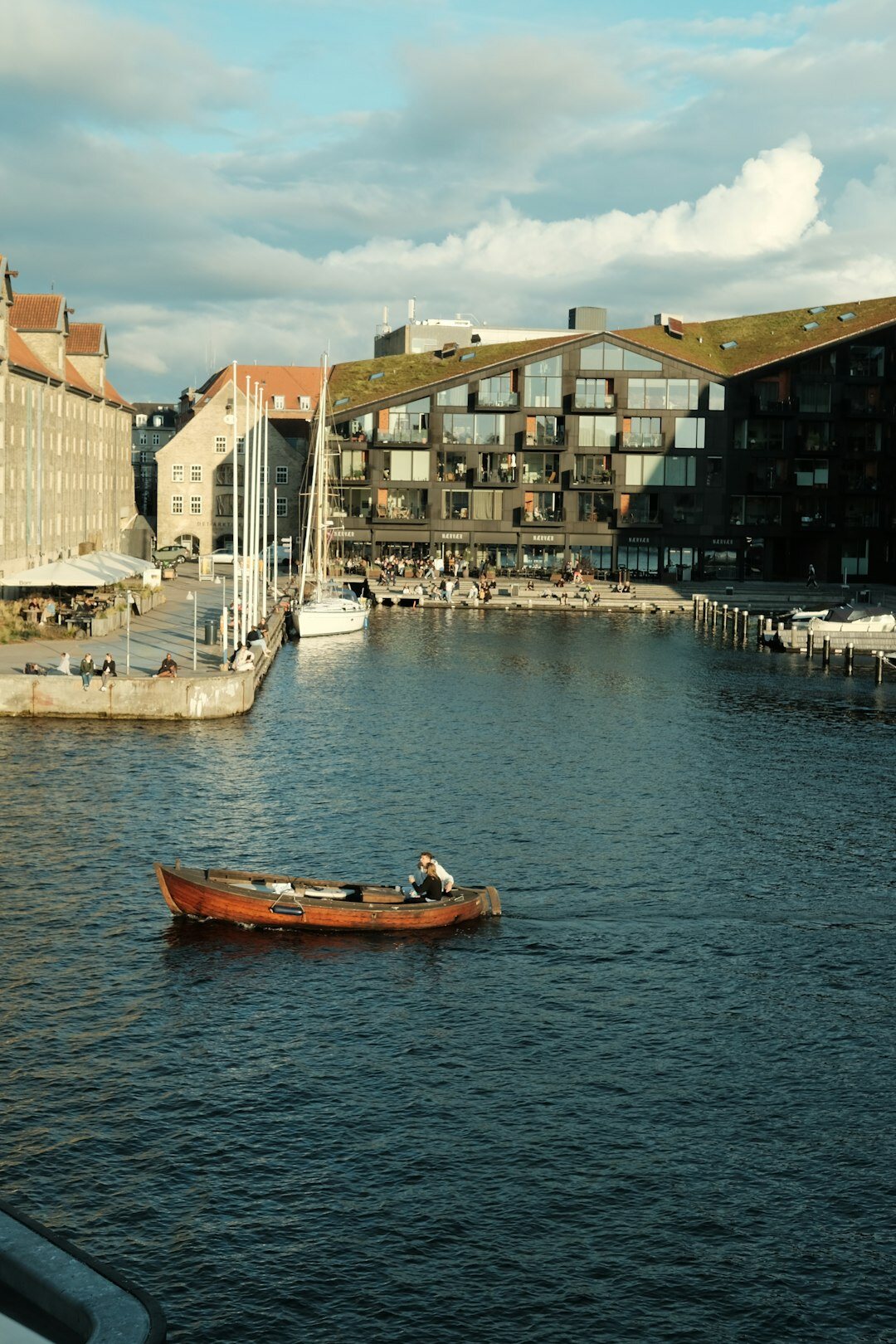 Elderly Danish fisherman mending fishing nets on a wooden boat